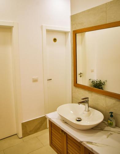 a bathroom with a sink and a mirror at Airport Garden Hotel in Rinas