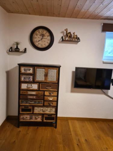a clock on a wall next to a dresser at Apartment Huter in Jerzens