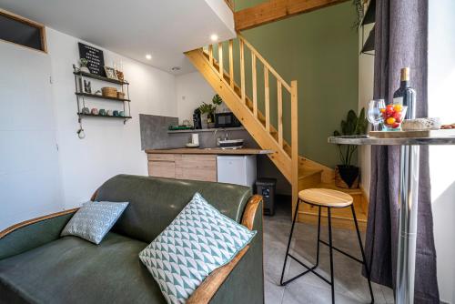 a living room with a green couch and a kitchen at le Chartreuse / Rent4night Grenoble in Grenoble