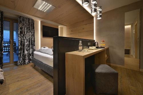 a bedroom with a bed and a desk in a room at Hotel Compagnoni in Livigno