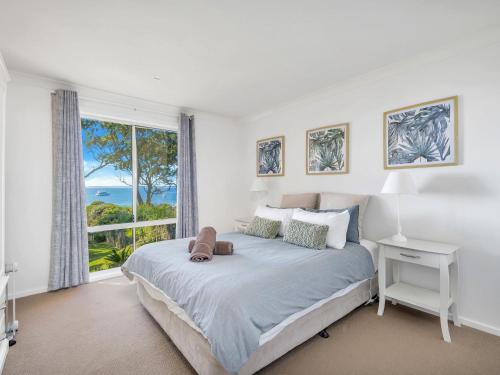 a bedroom with a bed with a view of the ocean at On The Beach at Vincentia in Vincentia