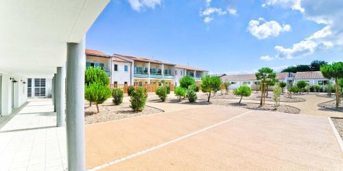 an empty parking lot in front of a building at Hôtel Les Grenettes in Sainte-Marie-de-Ré