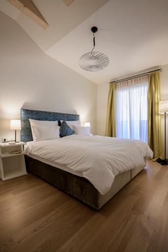 a bedroom with a large bed and a window at Hotel Bruneck Design-Suites in Brunico