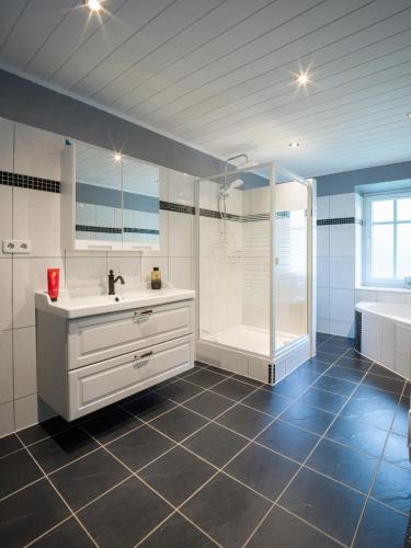 a bathroom with a shower and a sink and a tub at Villa Mondial in Wadern
