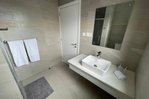a white bathroom with a sink and a mirror at Bois Mapou Self Catering Apartments Unit 202 in Rivière Noire