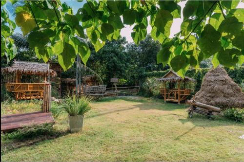 un groupe de cabanes dans une cour avec de l'herbe dans l'établissement Phuket Nonnita Boutique Resort - SHA Plus, à Phuket