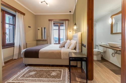 a bedroom with a bed and a bathroom with a sink at Ef Zin Hotel Arachova in Arachova