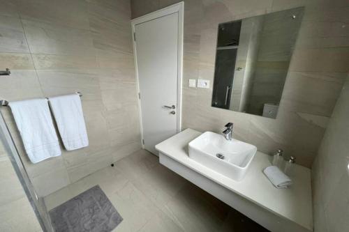 Baño blanco con lavabo y espejo en Bois Mapou Self Catering Apartments Unit 203 en Rivière Noire