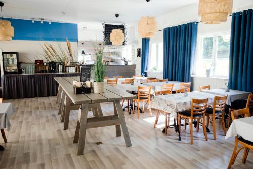 een eetkamer met blauwe gordijnen en tafels en stoelen bij Visby Gustavsvik in Visby
