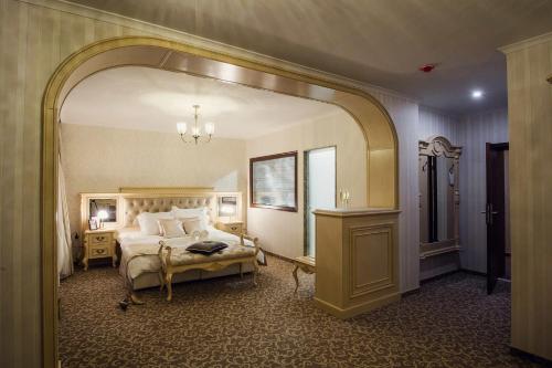 una camera con un letto e un grande specchio di Hotel Forum a Pazardžik
