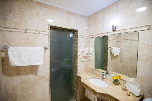 a bathroom with a sink and a shower at Hotel Forum in Pazardzhik
