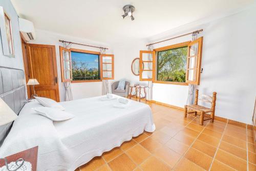 1 dormitorio con 1 cama blanca y 2 ventanas en Villa Auba, en Port de Pollença (Puerto Pollensa)