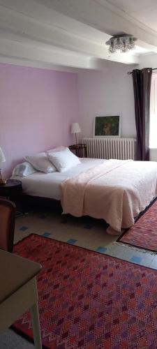 a bedroom with a large white bed in a room at Le Clos Marie in Brénod