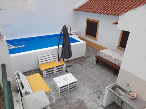 a balcony with a table and chairs and an umbrella at Casa Zé Actor in Cabeção