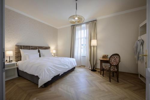a bedroom with a bed and a desk and a window at Hotel Bruneck Design-Suites in Brunico