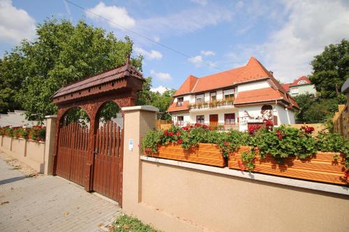 a house with a fence and a gate with flowers at Székely Kúria in Miskolctapolca