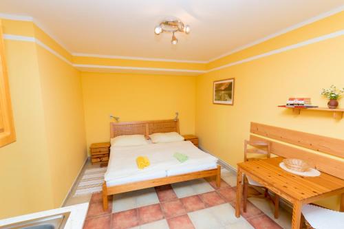 Schlafzimmer mit einem Bett und einem Tisch in der Unterkunft Apartments U Jezera Černá in Černá v Pošumaví