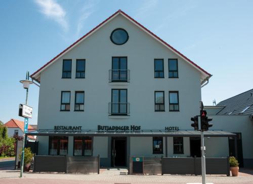 a white building on a street corner with a traffic light at Butjadinger Hof in Burhave