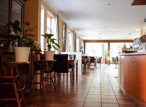 a restaurant with tables and chairs in a room at Butjadinger Hof in Burhave
