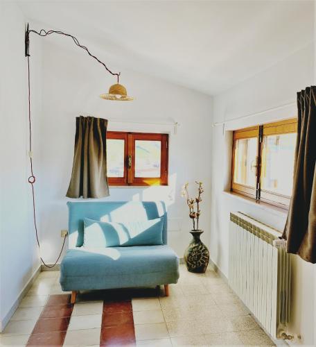 a living room with a blue chair and window at B&B Agorà in Biccari