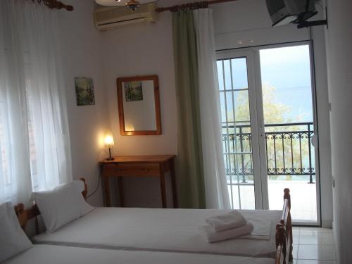 a bedroom with two beds and a large window at Veroniki Apartment in Skala Marion