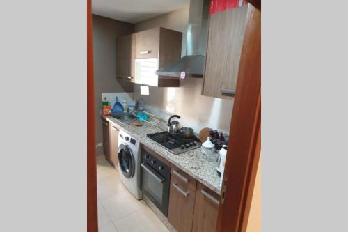 uma cozinha com um fogão e uma máquina de lavar louça em Apartment Near & close to Casablanca Mohammed V International Airport em Nouaseur