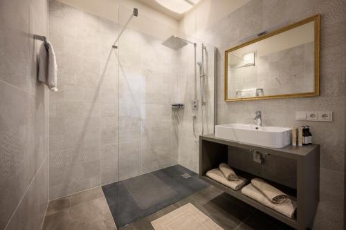 a bathroom with a sink and a shower at Hotel Bruneck Design-Suites in Brunico