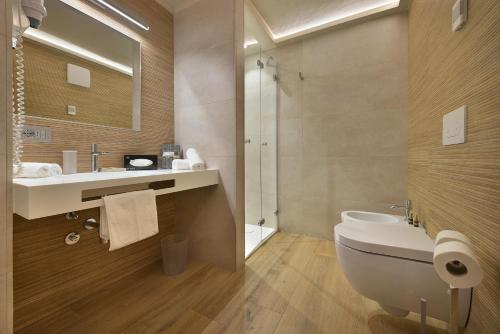 a bathroom with a sink and a toilet and a shower at Hotel Compagnoni in Livigno