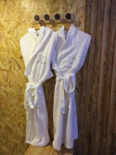 a group of white towels hanging on a rack at Le Ptit Spa de L'Abbaye Suite love et Spa privé in Lonlay-lʼAbbaye