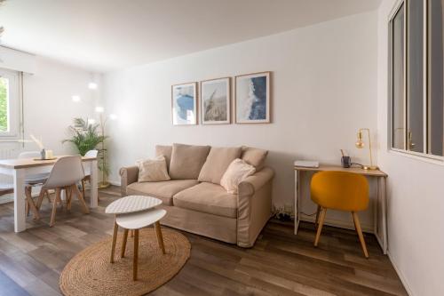 a living room with a couch and a table at HYGGE - Superbe Apt rénové Rouen Gare avec parking privatif in Rouen