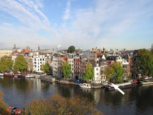 a view of a city with a river and buildings at Amsterdam Canal Guest Apartment in Amsterdam