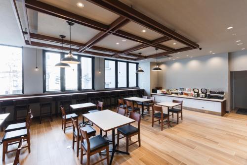 広島市にある相鉄フレッサイン広島のテーブルと椅子のあるレストラン、キッチンが備わります。