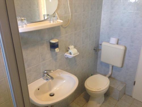 a small bathroom with a toilet and a sink at Motel Hummel in Pér