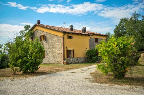 a small stone house with two trees in front of it at Villaggio Della Salute Più in Monterenzio