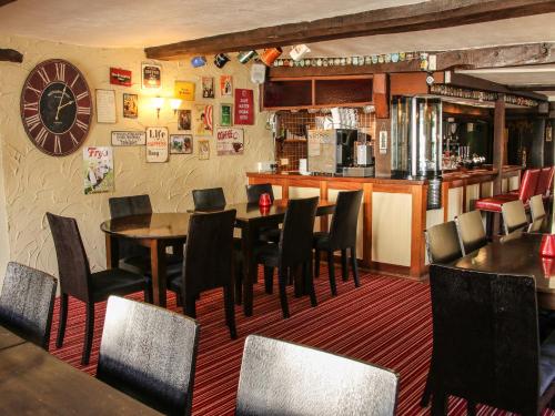 a restaurant with tables and chairs and a bar at The Boars Head Pub in Bishops Castle