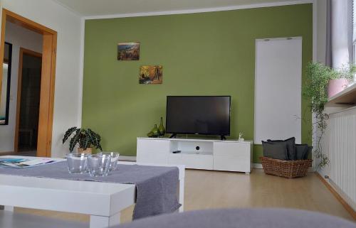 sala de estar con TV y mesa con gafas en Apartement am Waldrand, en Bad Wildbad