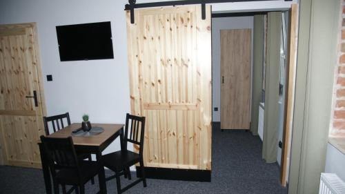 a dining room with a table and a wooden wall at Apartamenty Rycerskie in Inowłódz
