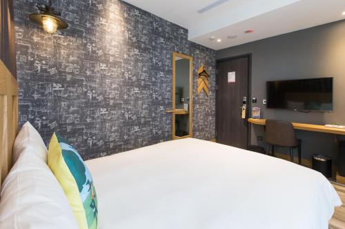 a bedroom with a large white bed and a wall at Norway Forest Travel hotel 3 Taichung in Taichung