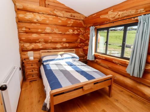 una camera con un letto in una baita di tronchi di Cedar Cabin a Worcester