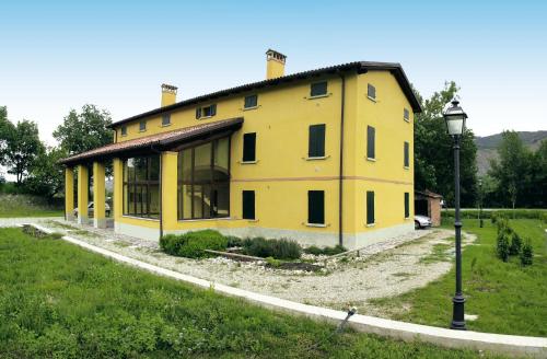 a yellow house in a field with a street light at Villaggio Della Salute Più in Monterenzio