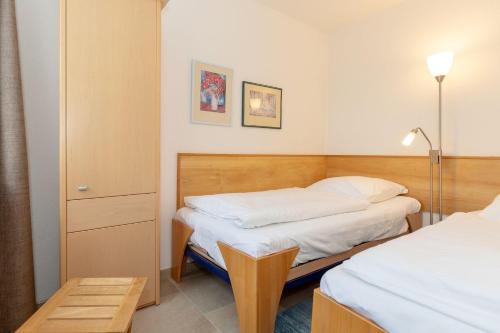 キュールングスボルンにあるHaus-Olymp-Wohnung-24-9506の小さなベッドルーム(ベッド2台、テーブル付)