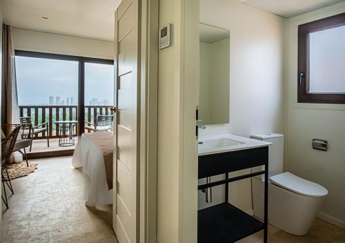 a bathroom with a sink and a view of a balcony at Grand Luxor Village in Benidorm