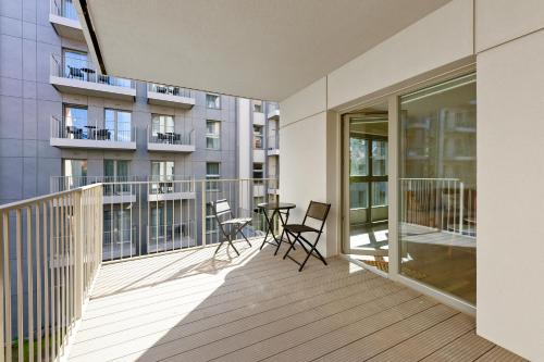 a balcony with chairs and a table and a building at GRANO APARTMENTS Gdańsk Old Town SPA & Wellness - GRANO APARTMENTS Gdańsk Residence SPA & Wellness in Gdańsk