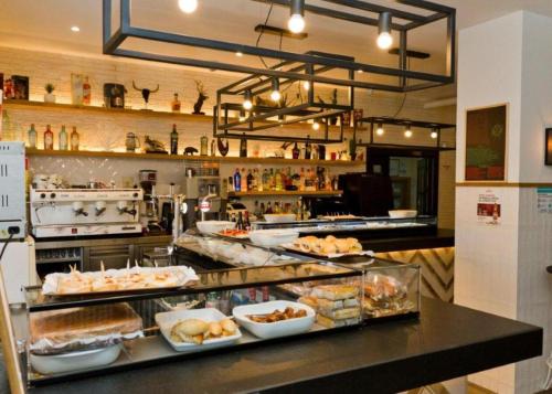 a bakery with a counter with many different food at Hostales Sol-Cristina y Sol-Cristina Dos in Segovia