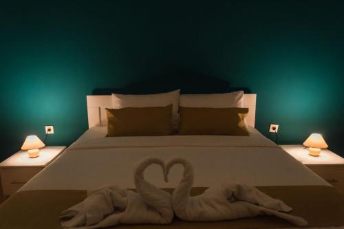 two swans made out of towels on a bed at Aatma Apartment in Skopje