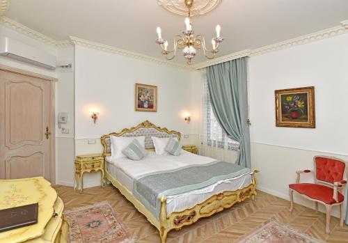 a bedroom with a bed and a chandelier at Royal Hotel in Varna City