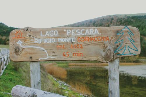 a wooden sign in front of a river at B&B Agorà in Biccari