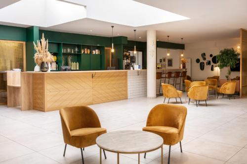 - une salle d'attente avec une table et des chaises dans l'établissement Best Western Hotel du Lac Dunkerque- Restaurant ouvert 7/7 midi et soir, à Armbouts-Cappel