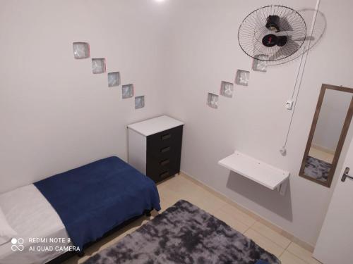 Schlafzimmer mit einem Bett, einem Ventilator und einem Spiegel in der Unterkunft KITNET DU VÔ in Santa Teresa