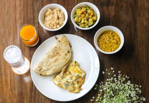 a table with a plate of food and bowls of food at Jatra Flagship Chattogram City Centre in Chittagong